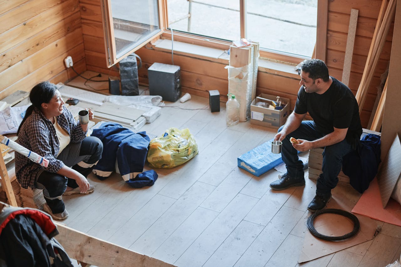 A Man and Woman Drinking Coffee While Talking in the Room